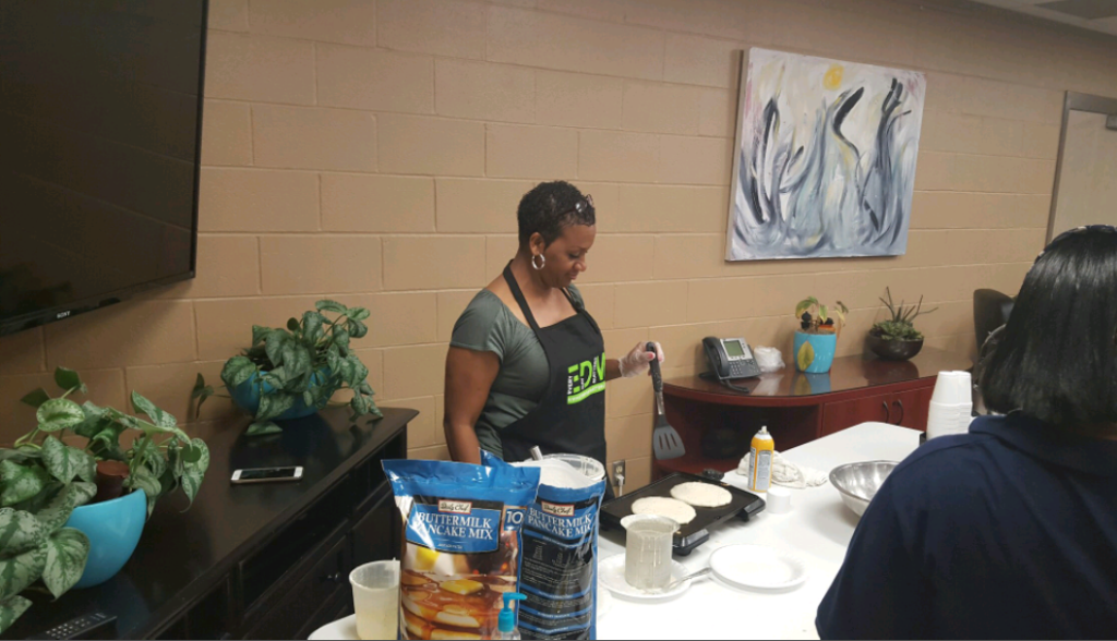 Regena Pearl, Associate Director of Residentail Services cooks pancakes for the staff breakfast.