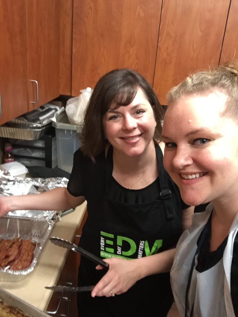 Lori Wheelhouse, Assoicate Director of Residential Services and Sara Schlagel, Assoicate Director of Hospital Services cook bacon and sausage for the breakfast.