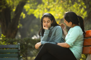 Mother comforting her daughter at park