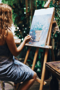 Lady sitting at easel painting a photo