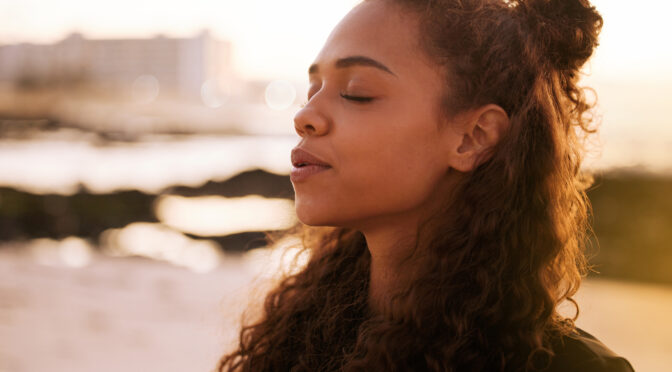 woman closing her eyes, reflecting and meditating