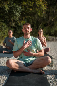 three people pictured practicing breathing and meditation work