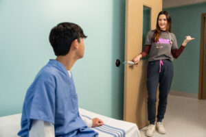 young boy in mental health hospital talking to behavioral health technician