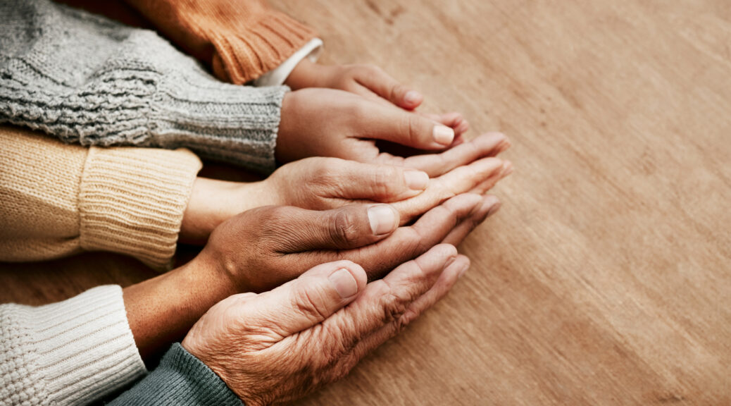 People, hands together and generations in care above on mockup for unity, compassion or trust on wooden table. Group holding hand in collaboration, love or support for community, teamwork or youth
