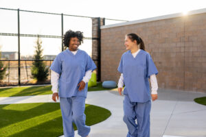two teens in a mental health hospital walking outside and getting healthy exercise 