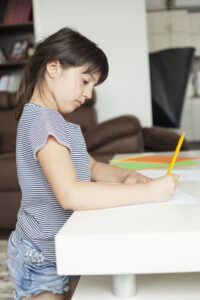 A neurodivergent child working on a school assignment at home.