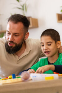Close-up of a parent and neurodivergent child focusing on homework, illustrating a coaching mindset for school success.
